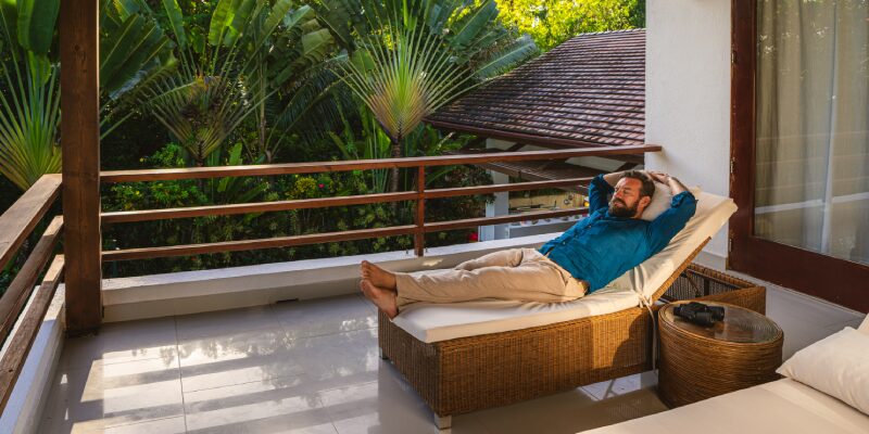 Na obrázku je muž, ktorý si užíva výhru v lotérii Eurojackpot v exotickej krajine.